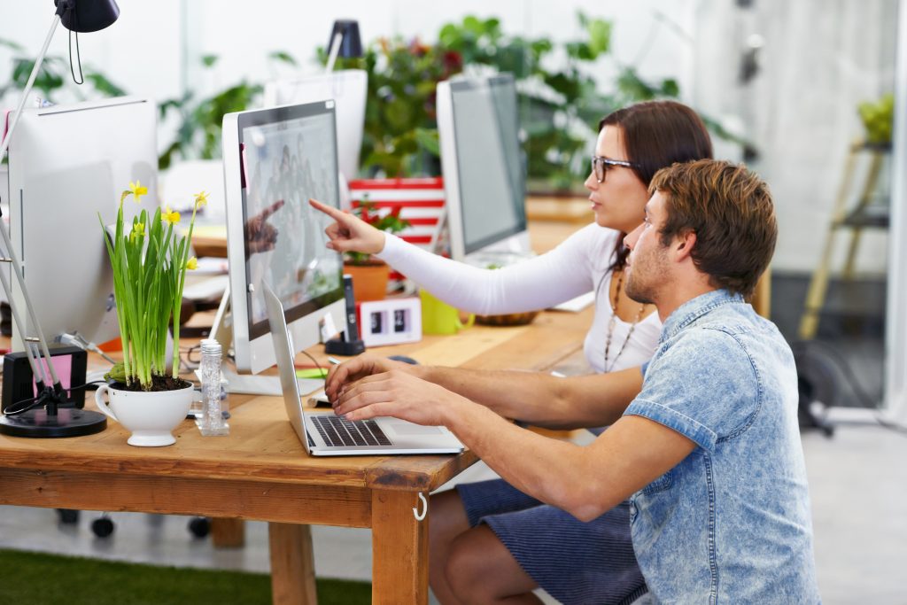 Website designer and small business owner discussing website strategy together.